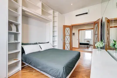a bedroom with a bed and shelves at Romaviva Luxury Attic Apartment - San Giovanni in Laterano - Metro A C - Central Rome in Rome