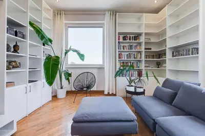 a living room with a blue couch and bookshelves at Romaviva Luxury Attic Apartment - San Giovanni in Laterano - Metro A C - Central Rome in Rome