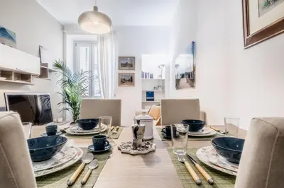 a dining room with a wooden table with plates and utensils at Roma Vatican Suites Inn in Rome