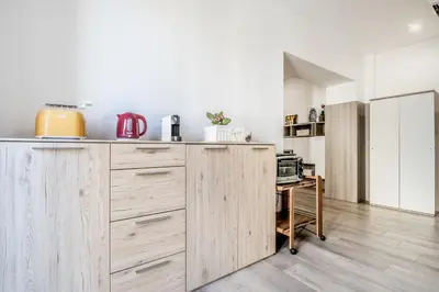 a kitchen with wooden cabinets and a microwave at Roma Vatican Suites Inn in Rome