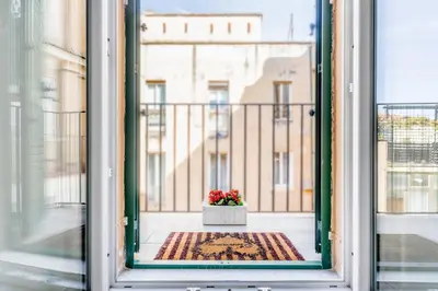 a window with a pot of flowers on a balcony at Roma Vatican Suites Inn in Rome