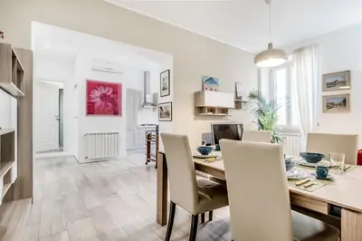 a dining room and living room with a table and chairs at Roma Vatican Suites Inn in Rome