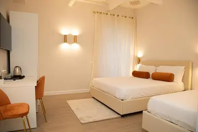 a bedroom with two beds and a table and a desk at Roxy luxury house Rome in Rome