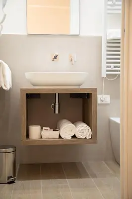 a bathroom with a sink and a shelf with towels at Roxy luxury house Rome in Rome