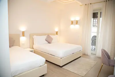 two beds in a white room with a window at Roxy luxury house Rome in Rome