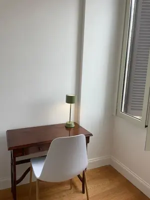 a desk with a white chair next to a window at Forte's Apartment in Rome