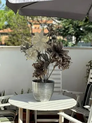 a vase of flowers sitting on a table at Vatican Green Penthouse in Rome