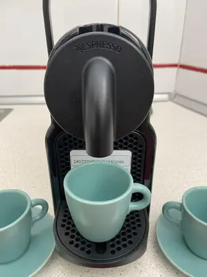 a black coffee maker with two cups on plates at Vatican Green Penthouse in Rome