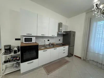 a kitchen with white cabinets and a sink and a microwave at Vacanze Romane Apartment in Rome in Rome