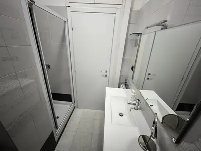 a white bathroom with a shower and a sink at Vacanze Romane Apartment in Rome in Rome