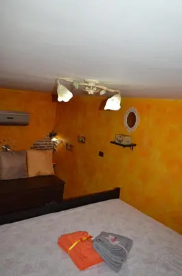 a bed with orange pillows and towels on it at La Casetta Gialla di Edoardo in Rome