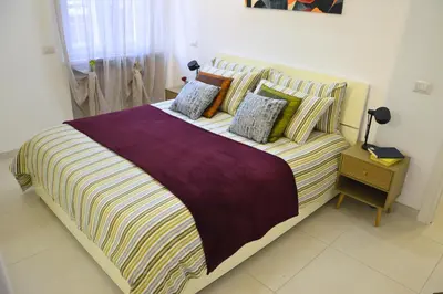 a bedroom with a large bed with striped sheets and pillows at Arese Undici in Rome