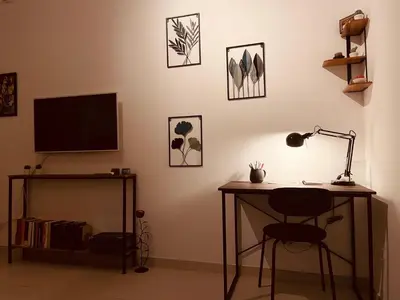 a desk with a lamp and a television on a wall at Arese Undici in Rome