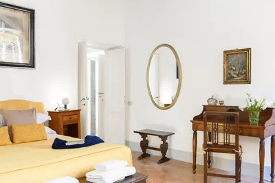 a bedroom with a bed and a desk and a mirror at Cartari Deluxe Apartment in Rome