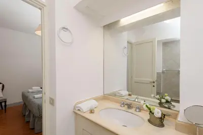 a bathroom with a sink and a mirror at Cartari Deluxe Apartment in Rome