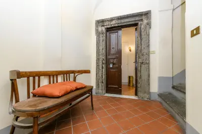 a wooden bench with an orange pillow sitting in a hallway at Cartari Deluxe Apartment in Rome