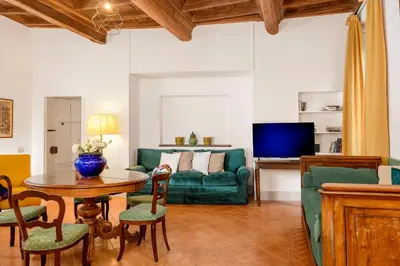 a living room with a green couch and a table at Cartari Deluxe Apartment in Rome