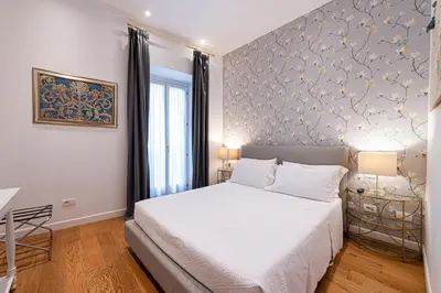 a bedroom with a bed and a blue and white wall at Piazza Venezia Suite and Terrace in Rome