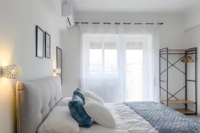 a white bedroom with a bed and a window at Veroli Vacanze Romane in Rome