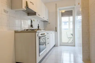 a kitchen with white appliances and a large window at Veroli Vacanze Romane in Rome