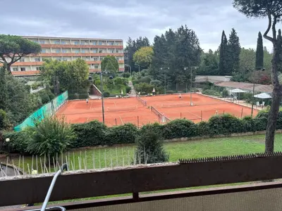 a large blue swimming pool with chairs and a building at Aurelia Antica Apartaments in Rome