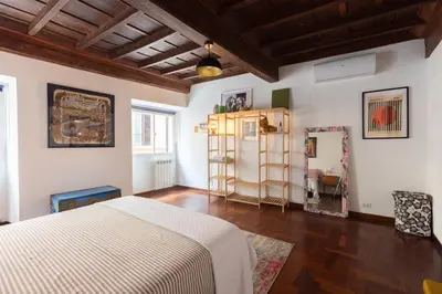 a bedroom with a white bed and a wooden floor at Perduta a Rome in Rome