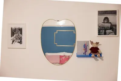 a mirror hanging on a white wall with pictures at Perduta a Rome in Rome
