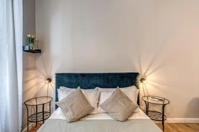 a bedroom with a bed with two chairs and two lamps at Fresh House Castel Sant' Angelo in Rome