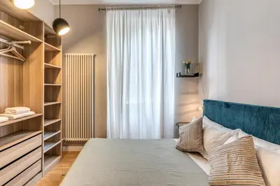a bedroom with a bed with a blue headboard and a window at Fresh House Castel Sant' Angelo in Rome