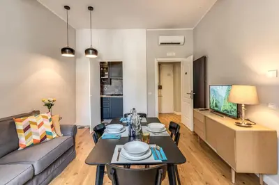 a living room with a couch and a table with chairs at Fresh House Castel Sant' Angelo in Rome