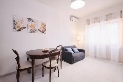 a living room with a table and a couch at Parcheggio gratuito, Wi-Fi -Netflix & AC in Rome