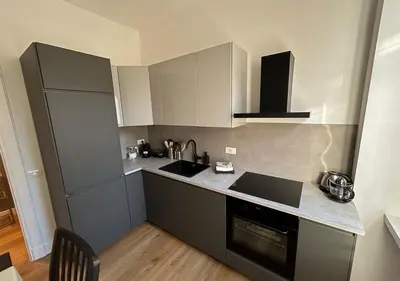 a kitchen with gray cabinets and a sink and a stove at Vatican Luxury Apartment in Rome