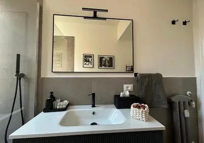 a bathroom with a sink and a large mirror at Vatican Luxury Apartment in Rome