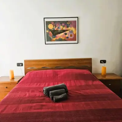 a bedroom with a red bed with two pillows on it at La casetta di Laura in Rome