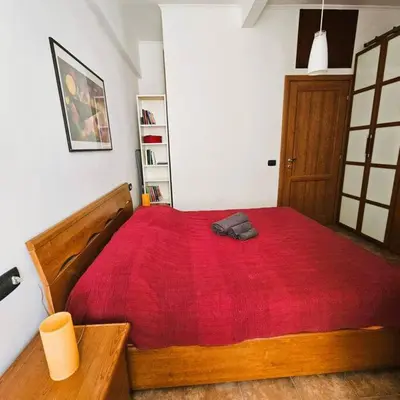 a bedroom with a large wooden bed with a red blanket at La casetta di Laura in Rome