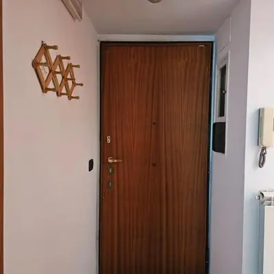 a wooden door in a room with a wall at La casetta di Laura in Rome