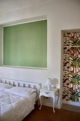 a bedroom with a bed and a greenboard on the wall at Suite 10 Parioli in Rome