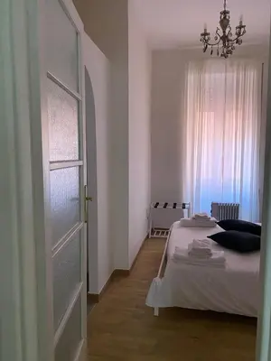 a bedroom with a bed and a window with a chandelier at Suite 10 Parioli in Rome