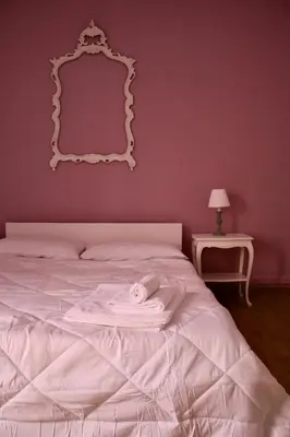 a bedroom with a white bed with a mirror on the wall at Suite 10 Parioli in Rome