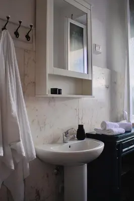 a white bathroom with a sink and a mirror at Suite 10 Parioli in Rome