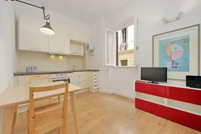 a kitchen with a table and a tv on a counter at Caprareccia In Monti by Halldis in Rome