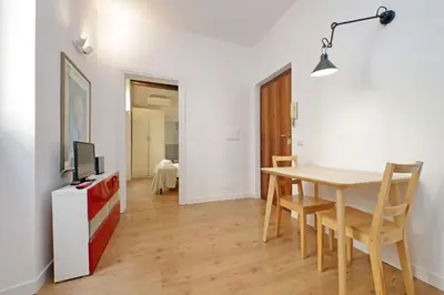 a dining room with a table and a tv at Caprareccia In Monti by Halldis in Rome