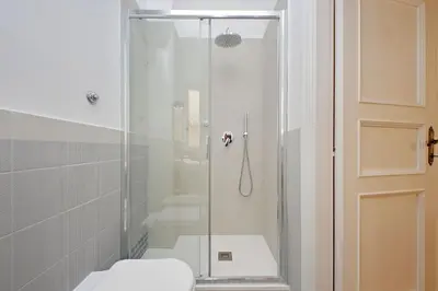 a bathroom with a glass shower with a toilet at Caprareccia In Monti by Halldis in Rome