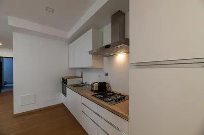 a kitchen with white cabinets and a stove top oven at Piazza Lodi - Apartment in Rome