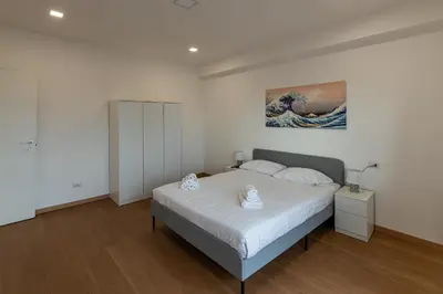 a bedroom with a bed and a painting on the wall at Piazza Lodi - Apartment in Rome