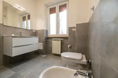 a bathroom with a toilet and a sink and a mirror at Piazza Lodi - Apartment in Rome