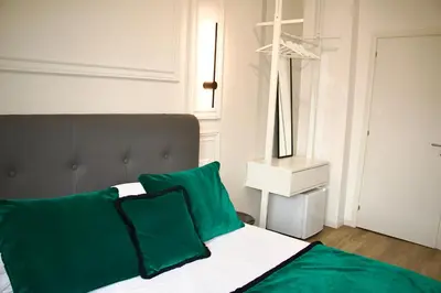 a bedroom with a bed with green and white pillows at XCross Suites Basilica San Paolo in Rome