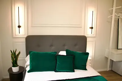 a bed with two green pillows on top of it at XCross Suites Basilica San Paolo in Rome