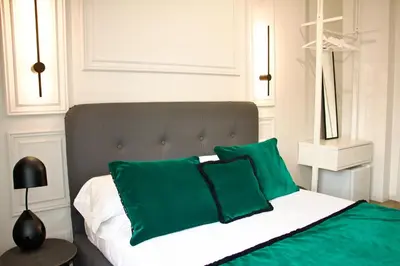 a bedroom with a bed with green pillows at XCross Suites Basilica San Paolo in Rome
