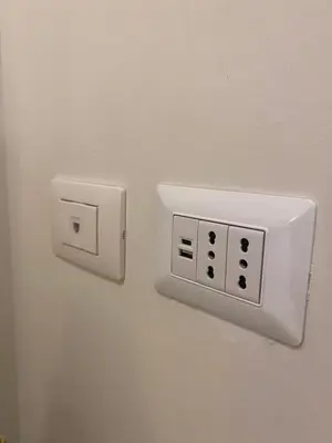 a white outlet on a wall with a plug at Secret Garden in Rome in Rome